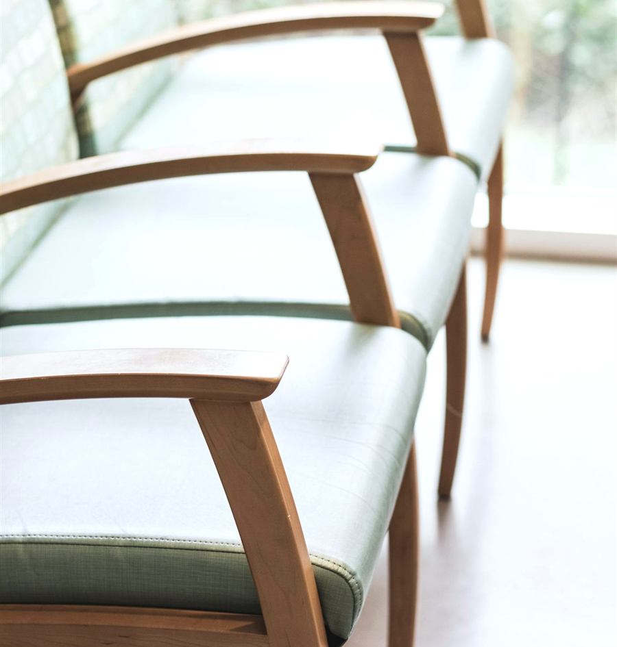 A quiet waiting room with wooden chairs